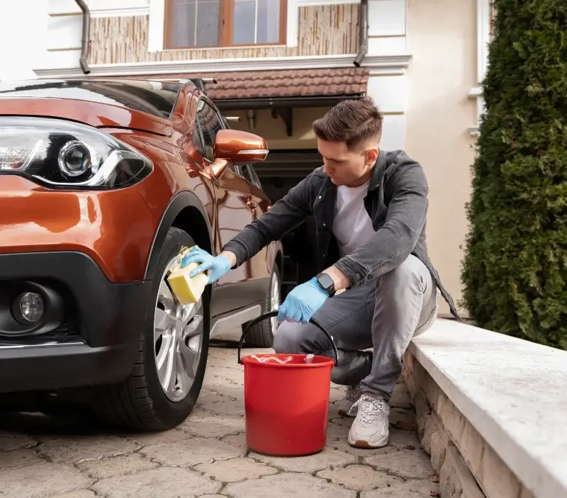 Lavage auto à domicile Ormesson-sur-Marne : professionnel intervenant sur un véhicule